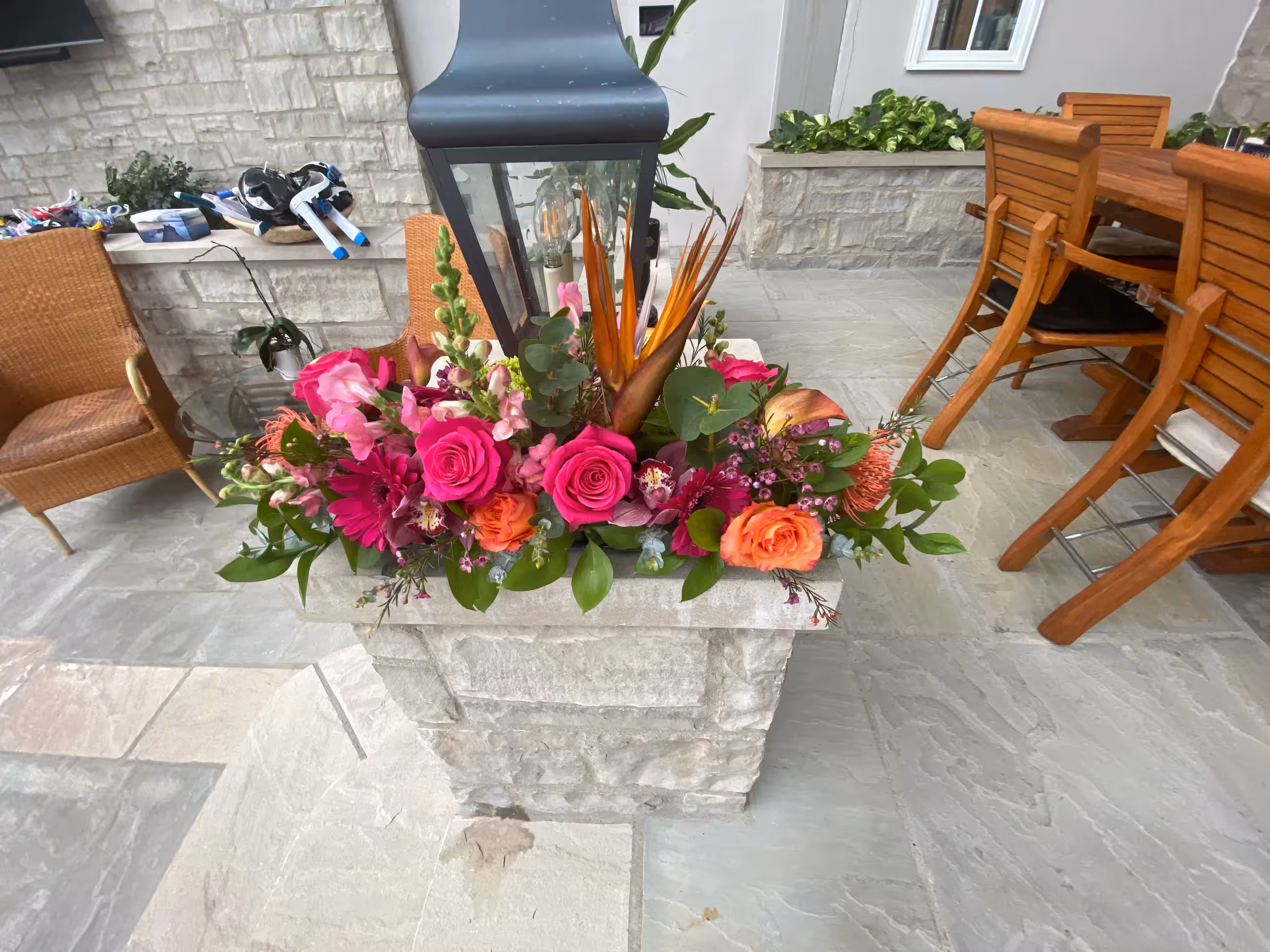 Pink orange tropical floral arrangement stone planter lantern