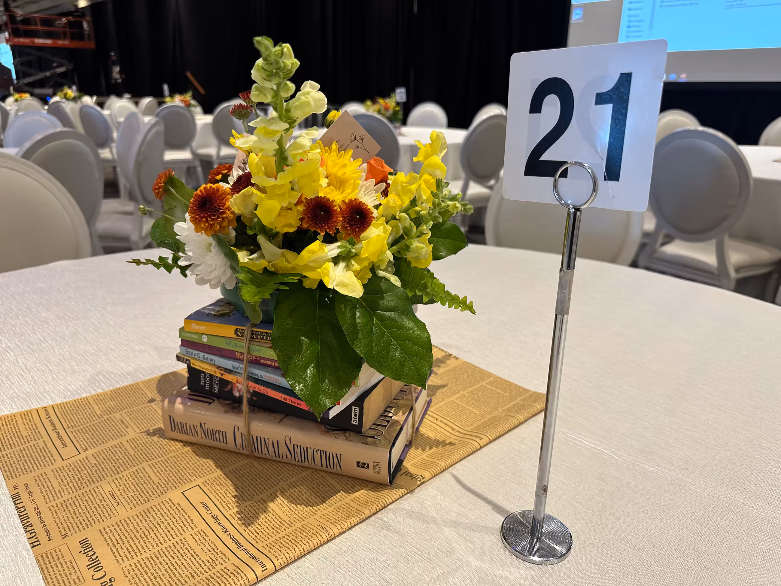 Yellow orange white floral arrangement book stack