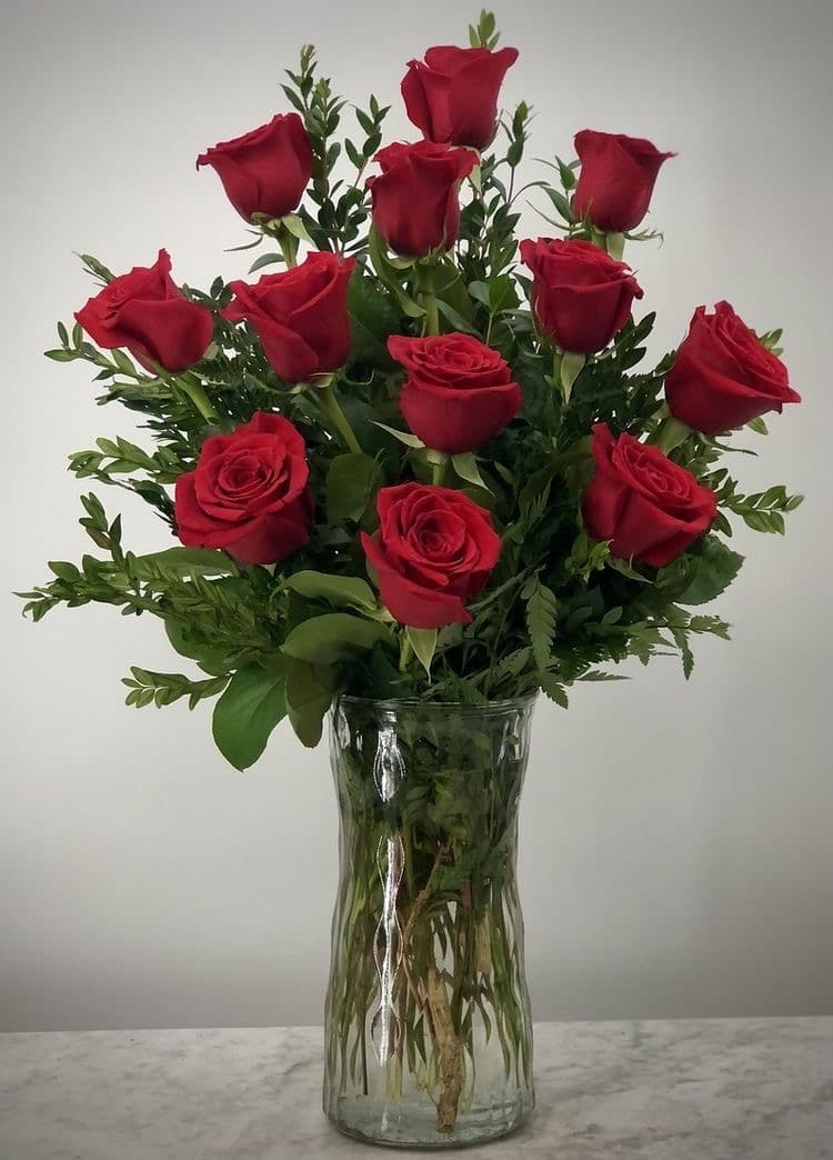 Classic Love arrangement featuring one dozen long-stem red roses and lush greenery