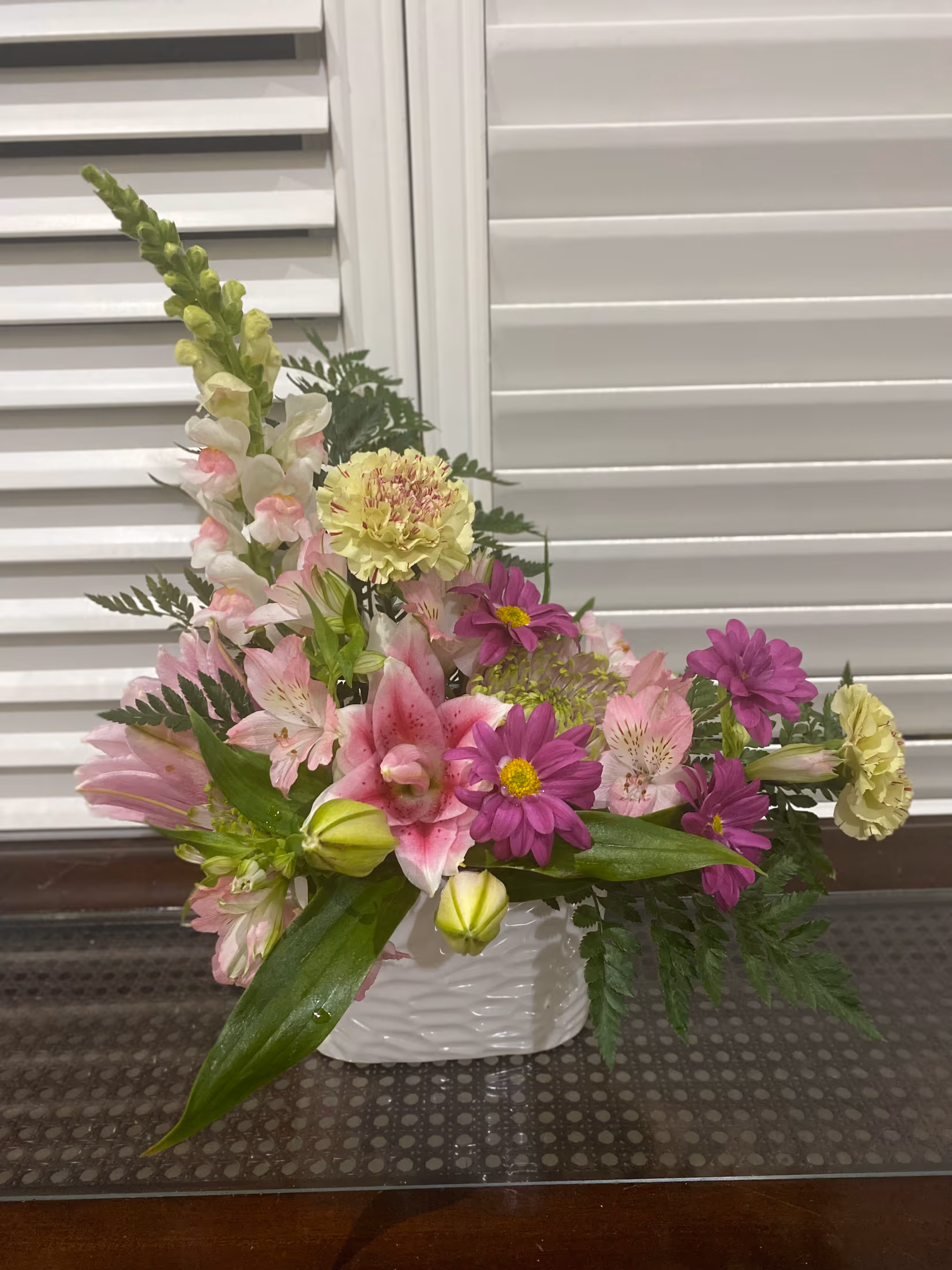 Elegant Love arrangement with lily roses, snapdragons, seasonal blooms, and greenery