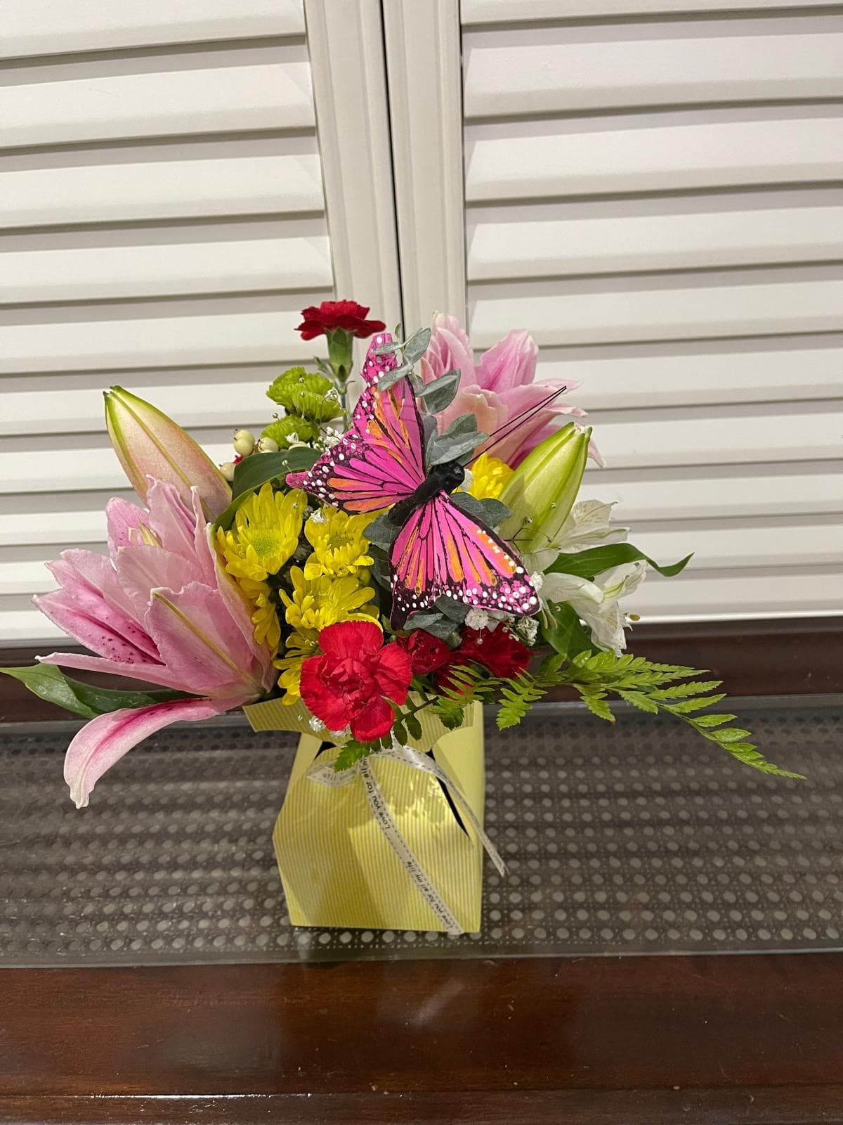 Friendship arrangement with assorted flowers and a decorative butterfly