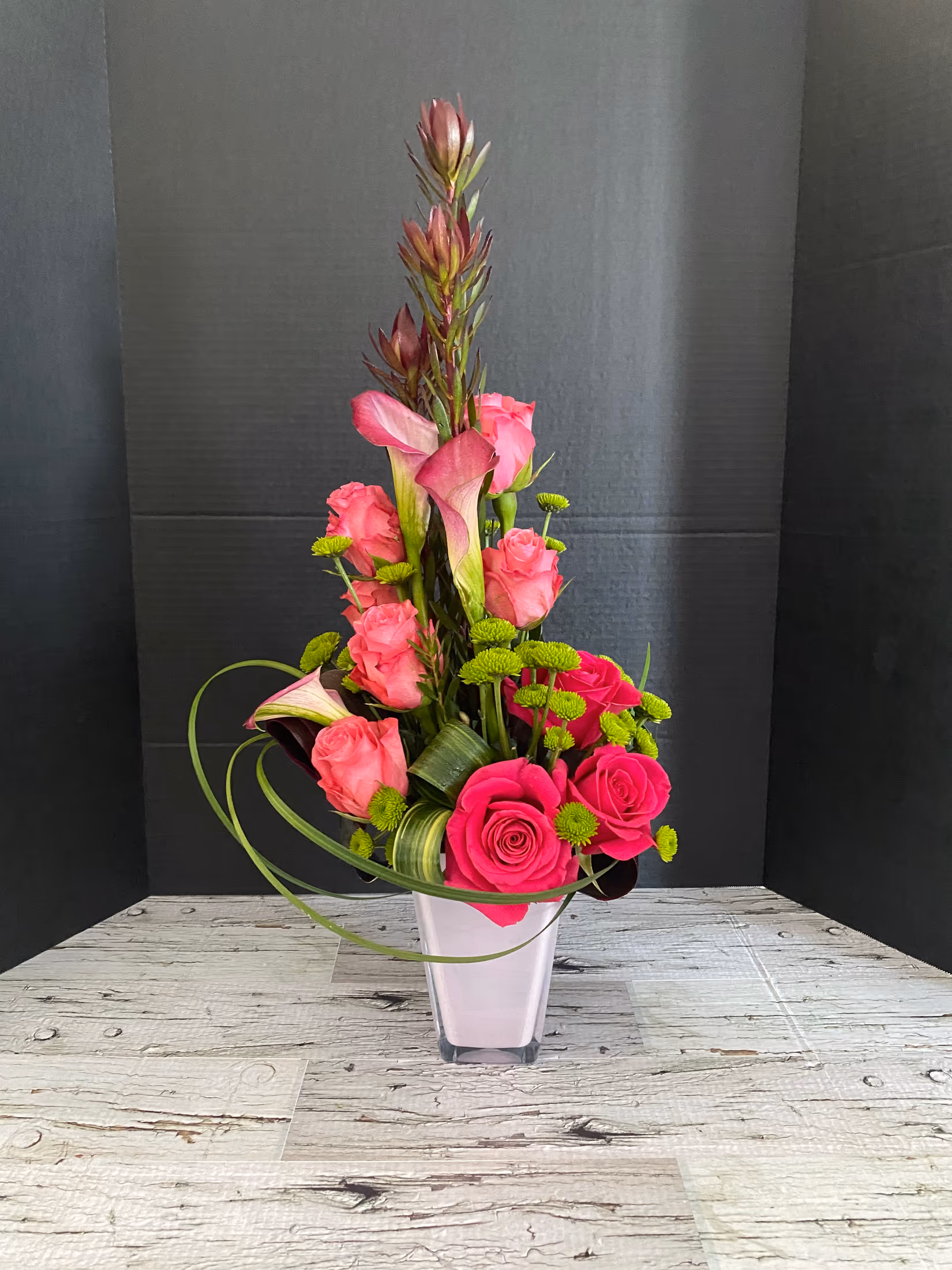 Pink Perfection arrangement with pink roses, calla lilies, leucadendron, and greenery