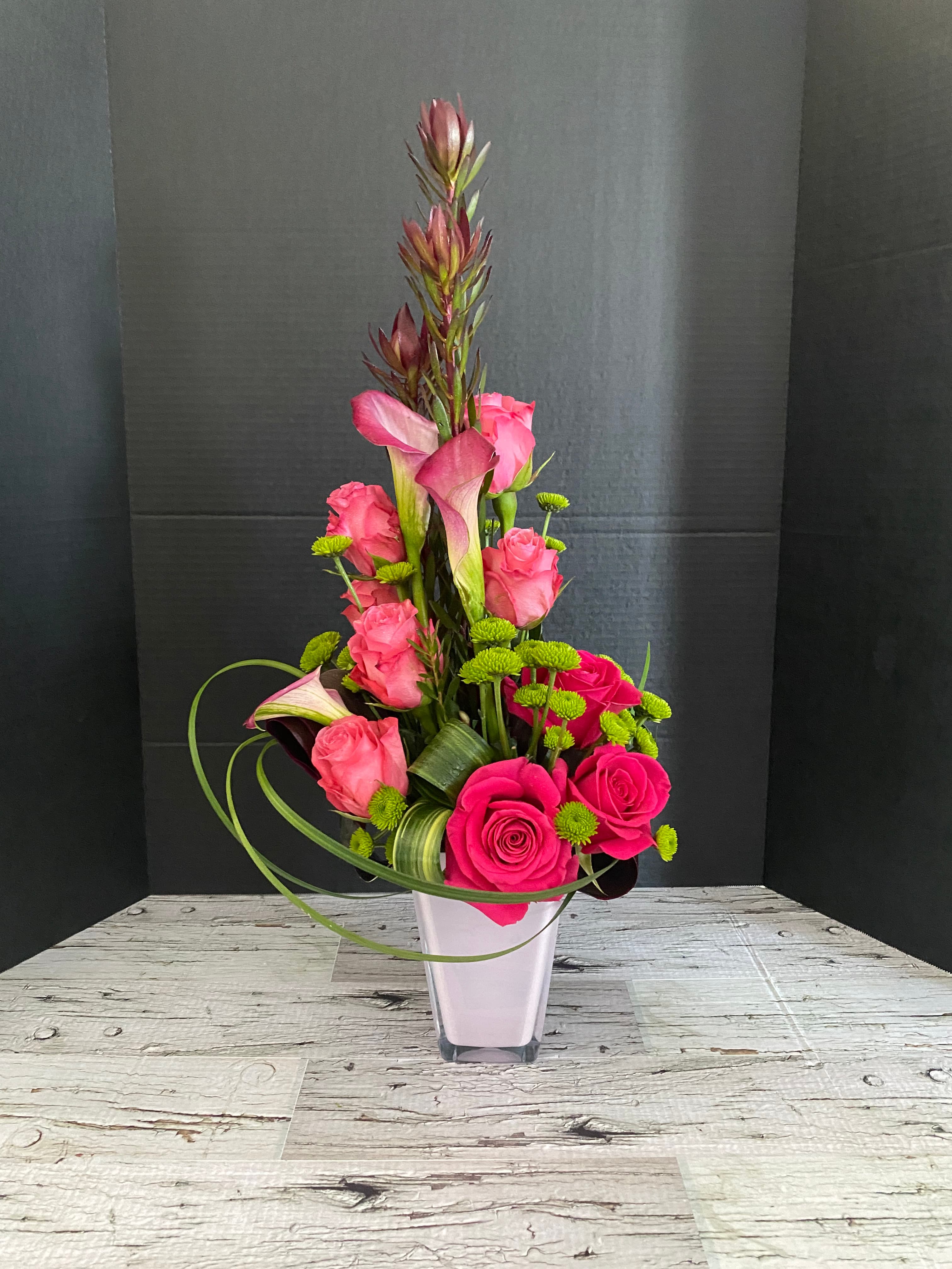 Pink Perfection arrangement with pink roses, calla lilies, leucadendron, and greenery