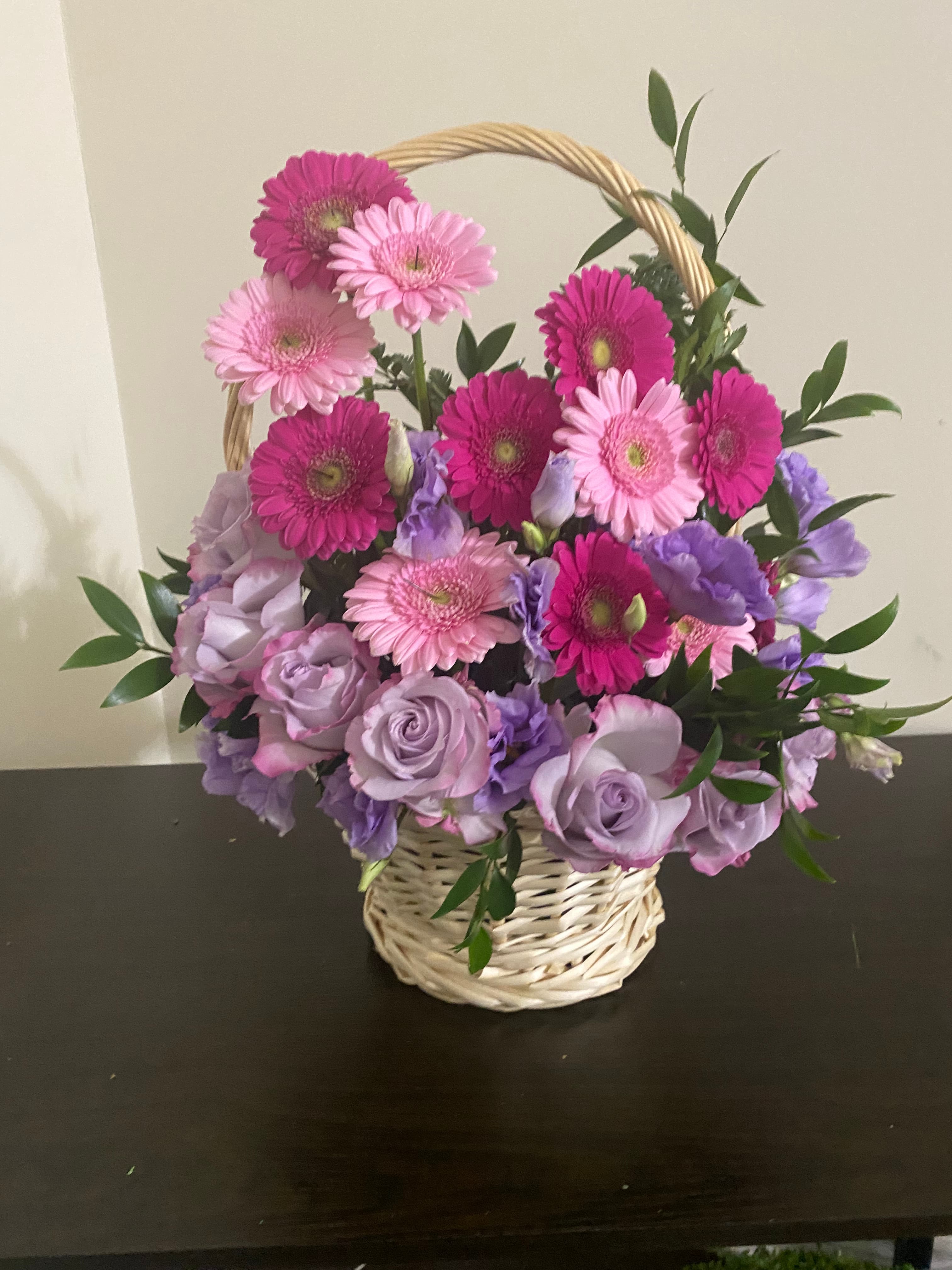 Riding Hood Basket arrangement with gerbera daisies, lilac roses, and purple lisianthus