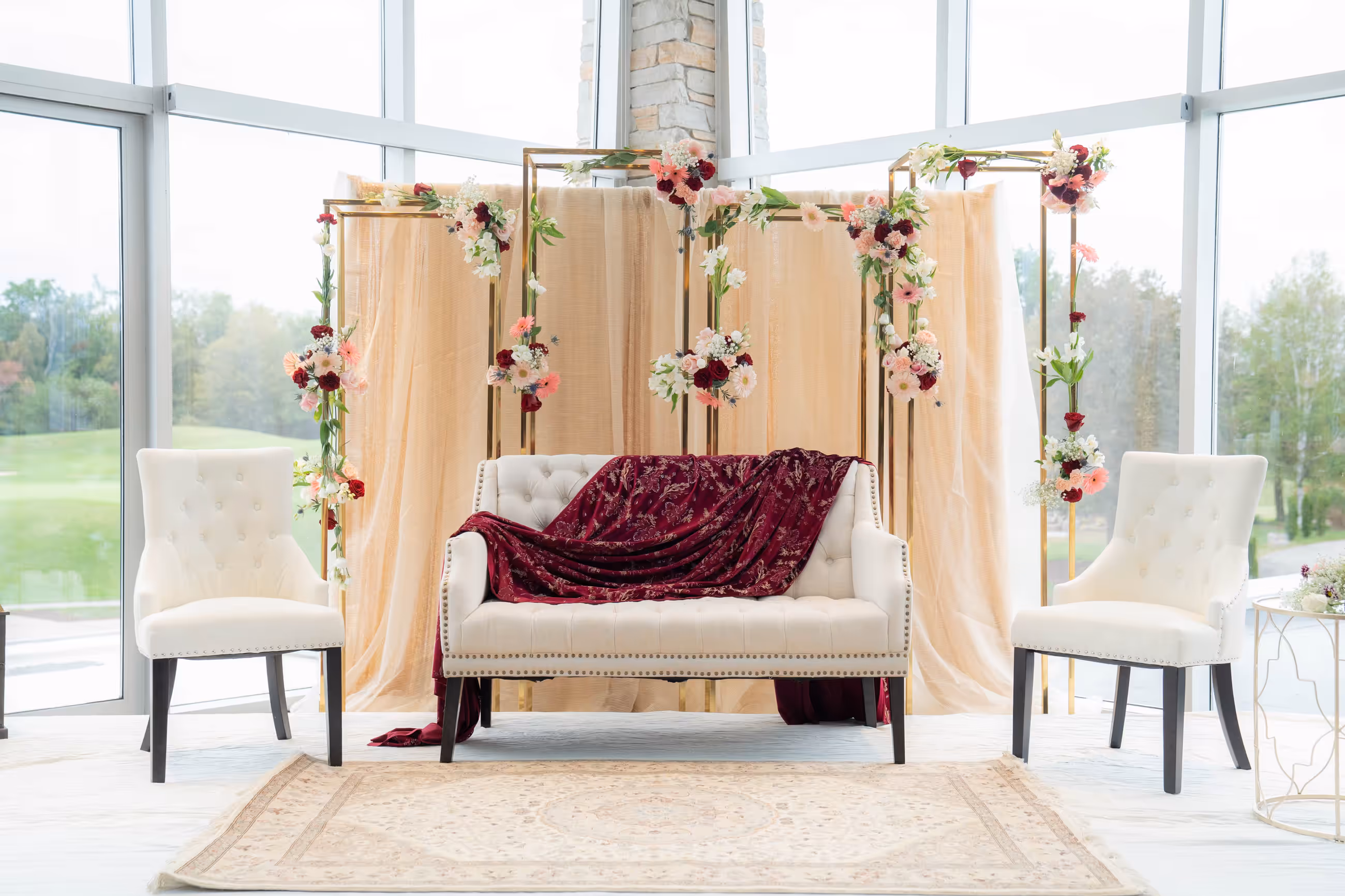 Cream floral backdrop with a burgundy lounge sofa