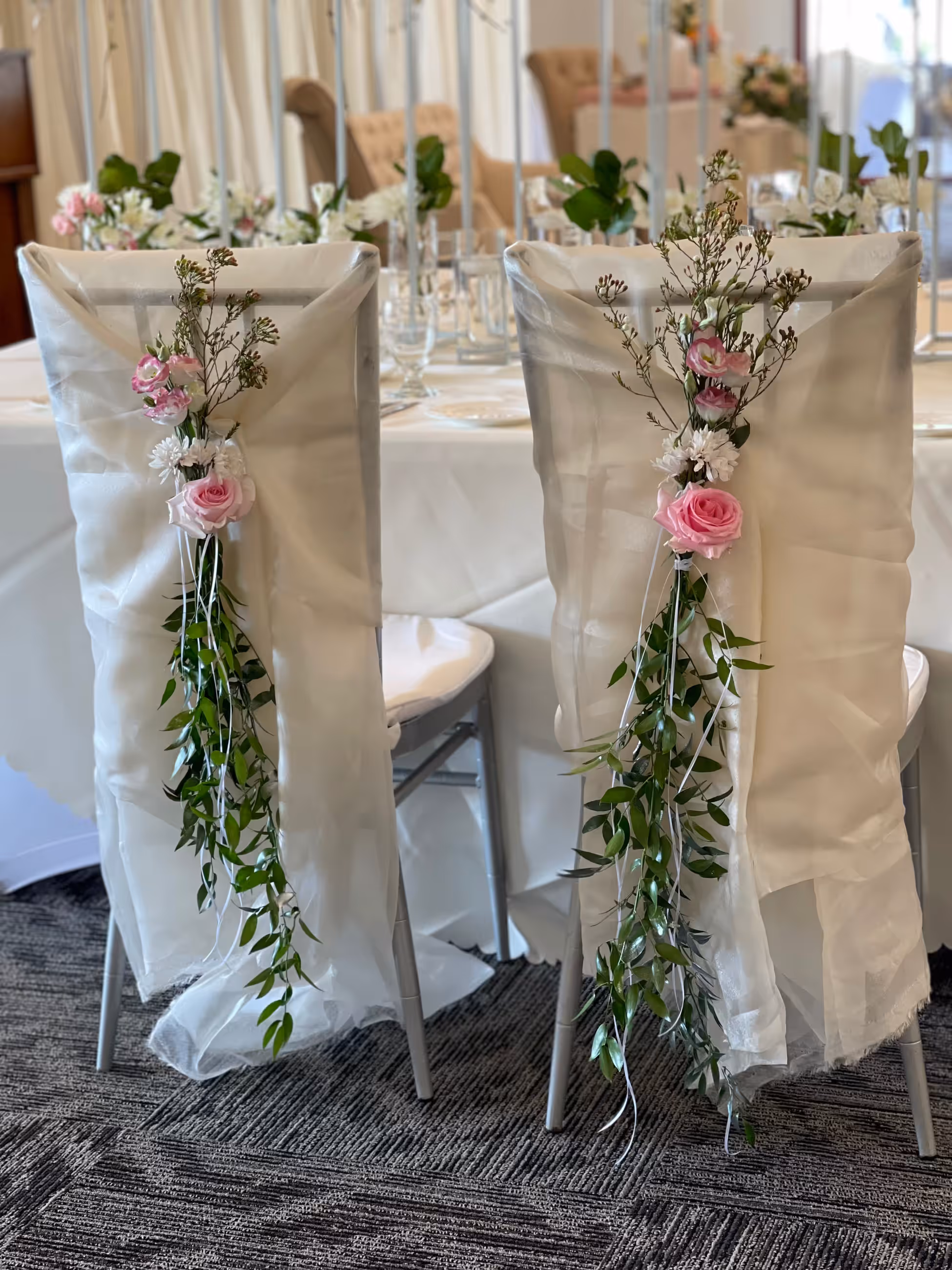 Pink floral garlands cascading down chair backs