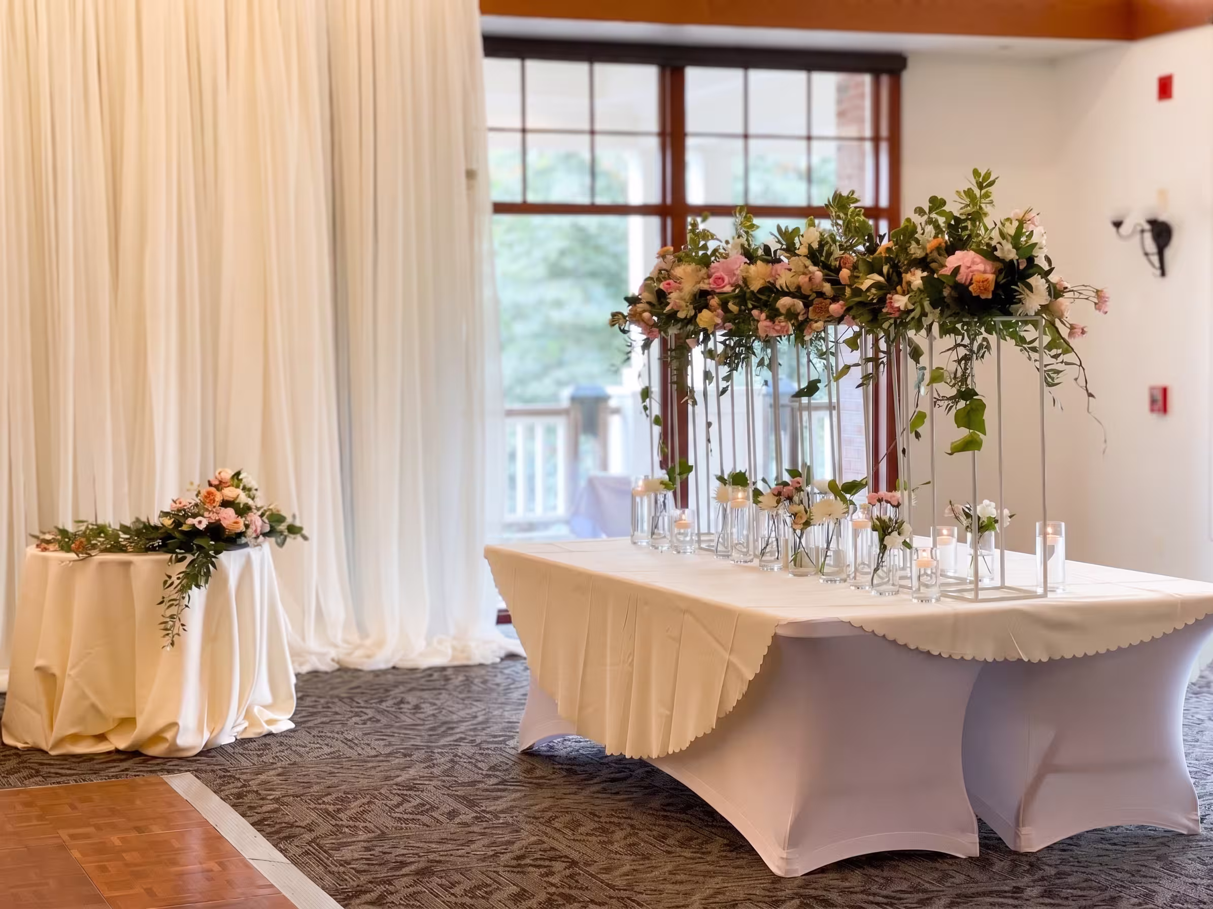 Pink and peach elevated floral arrangements flanking a head table