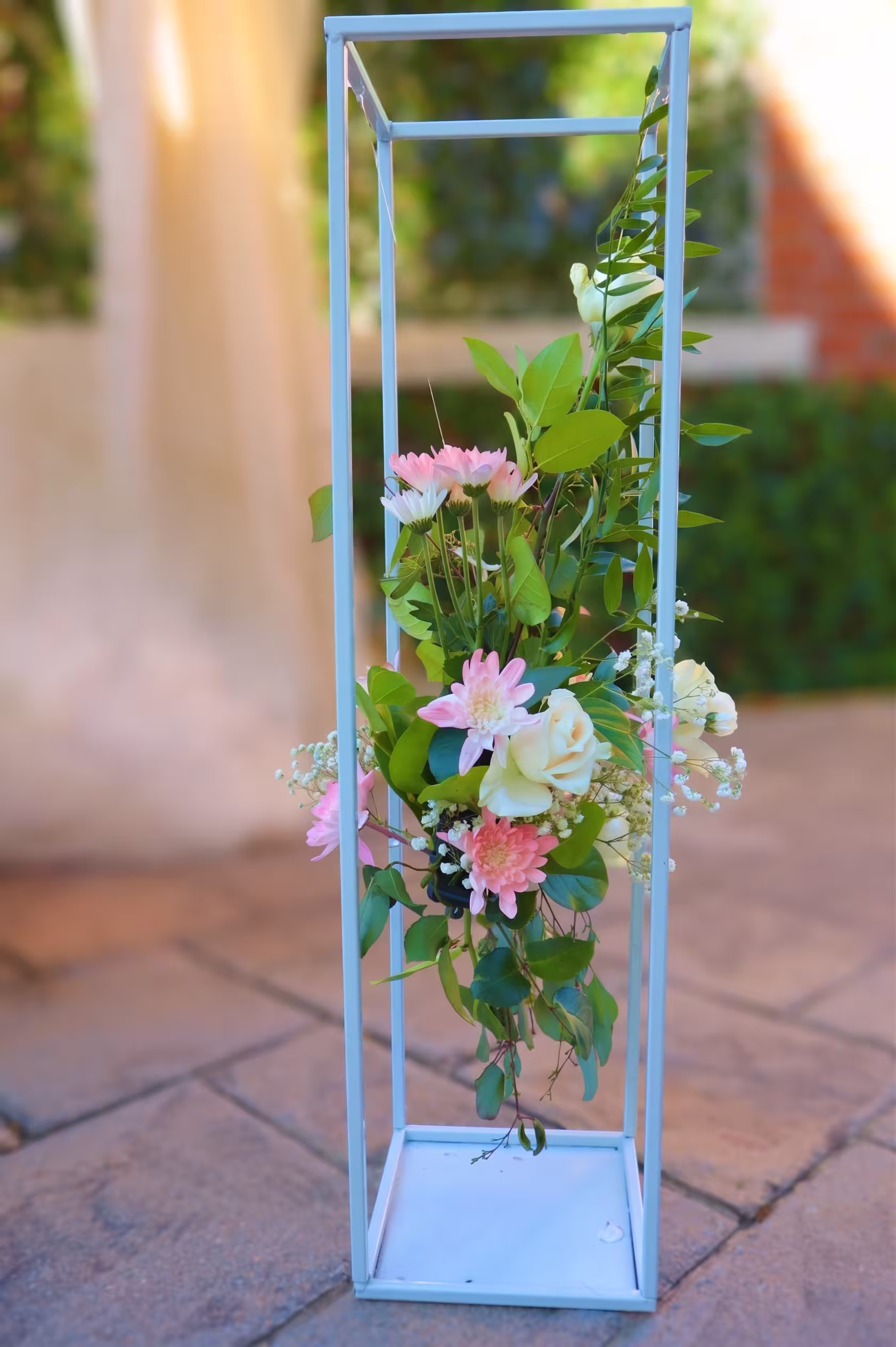 An elevated pink and white floral pillar arrangement
