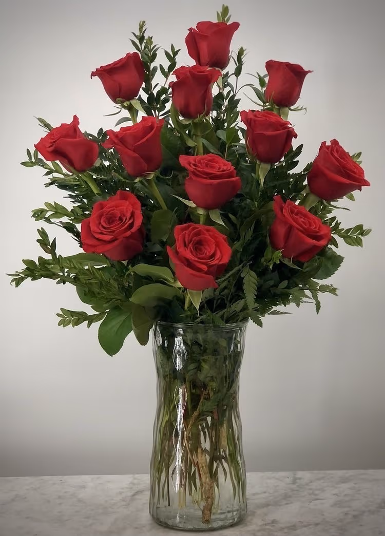 Classic Love arrangement featuring one dozen long-stem red roses and lush greenery